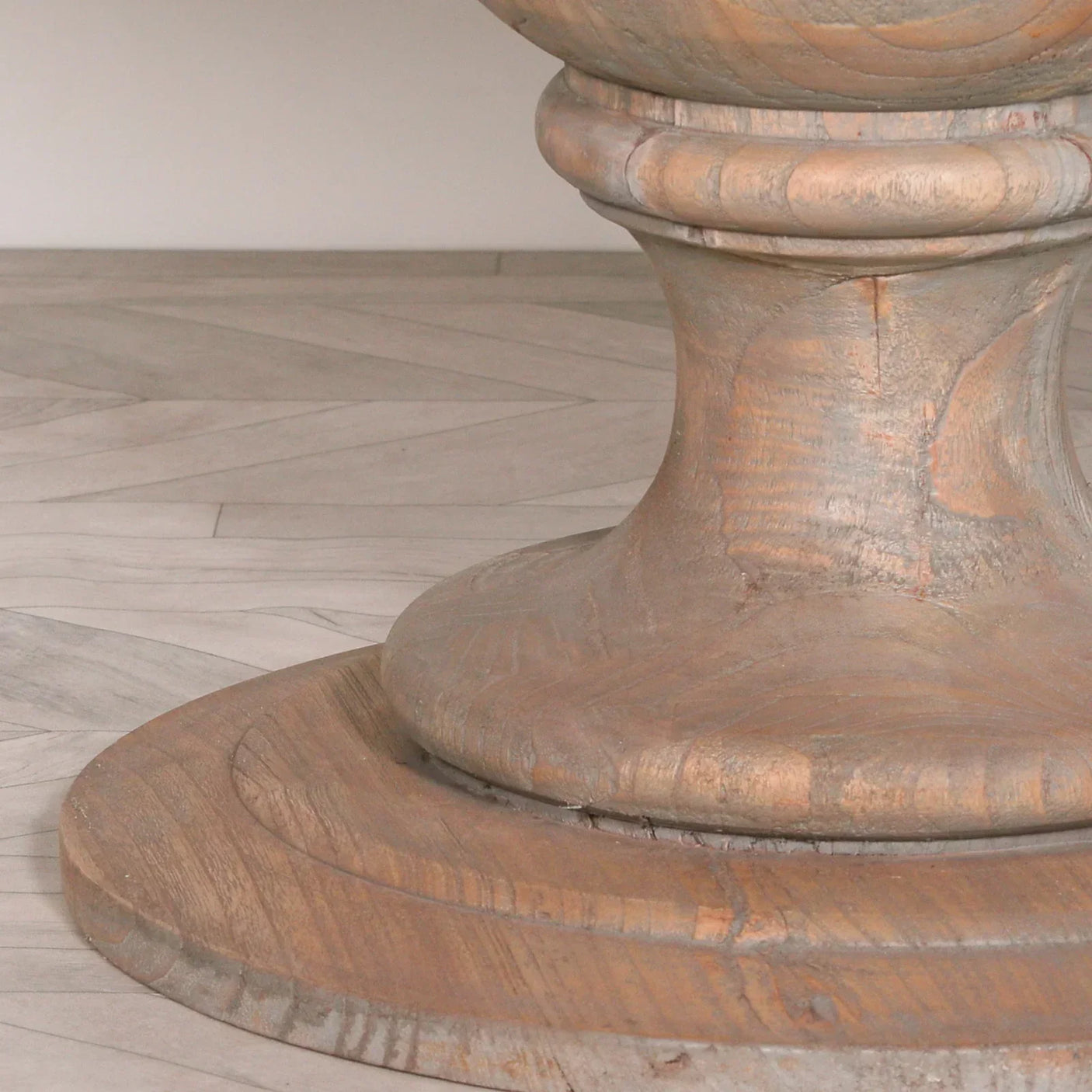 rustic wood dining table pedestal base on light herringbone floor