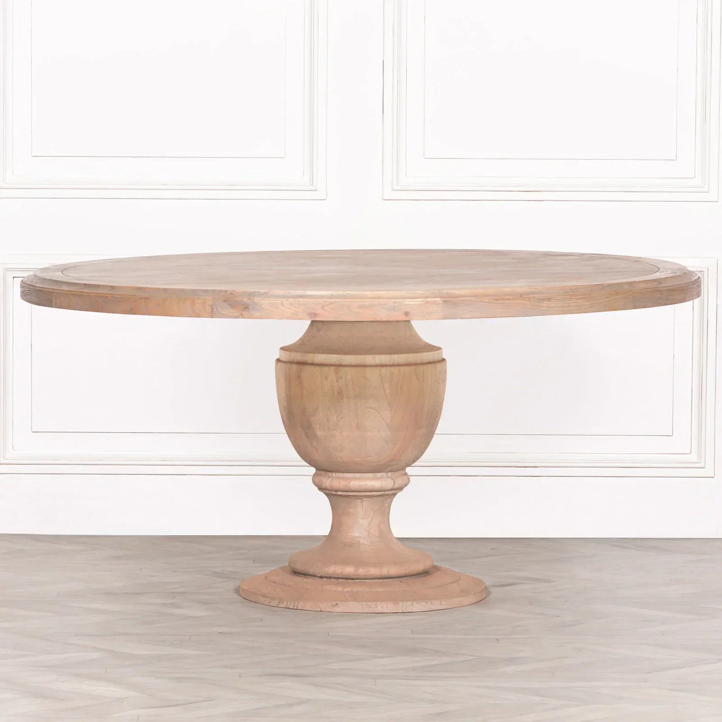 Round wooden dining table with pedestal base in minimal room