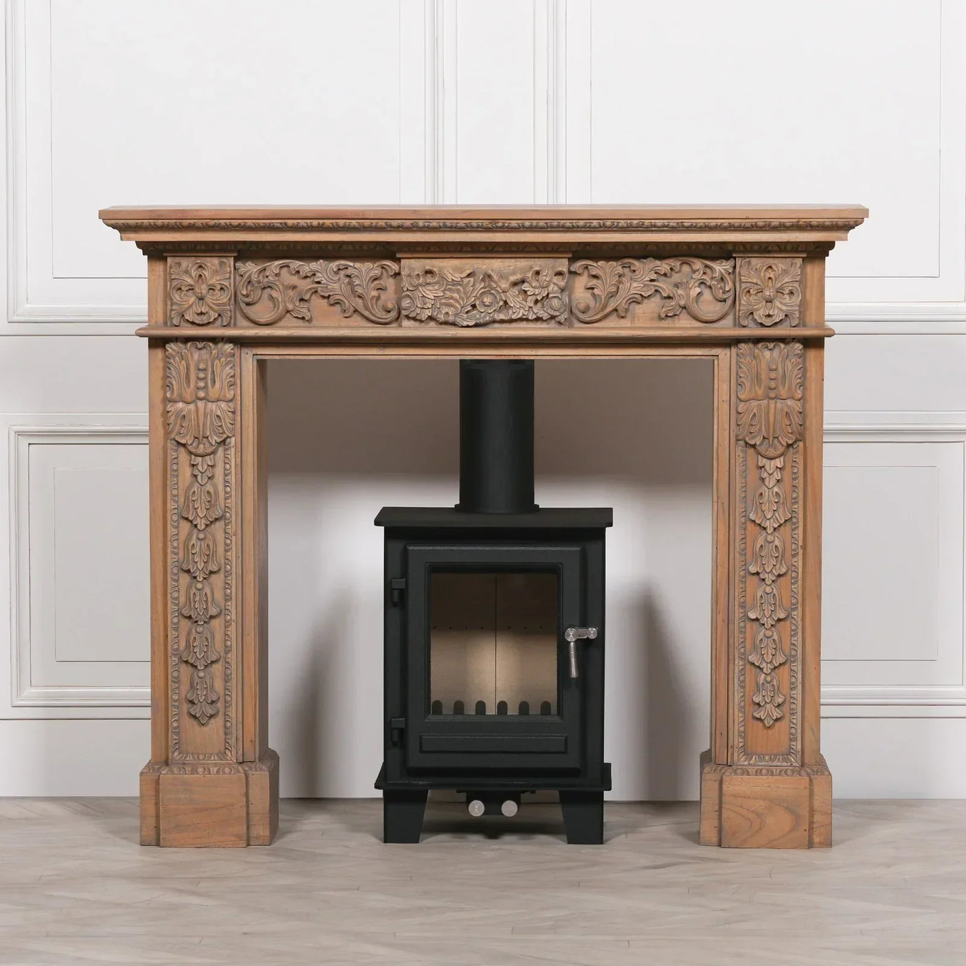 Carved wooden fireplace surround with black wood burning stove in classic interior setting