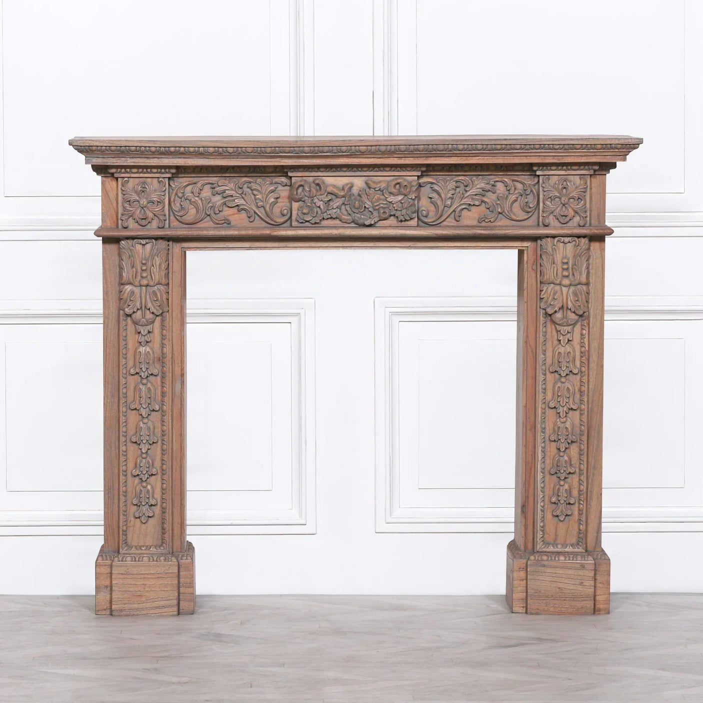 Carved wood fireplace surround with intricate floral detailing and natural finish
