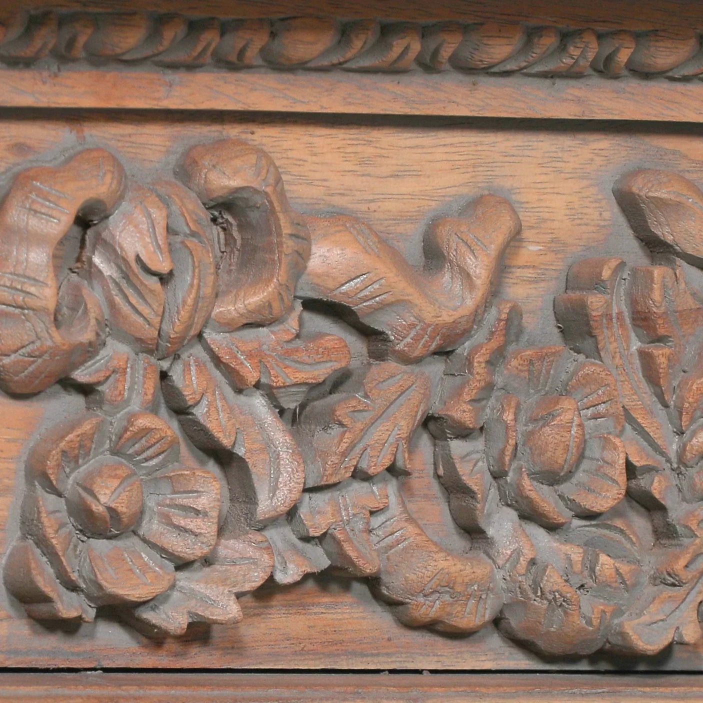 Carved wood furniture panel with floral detailing in natural brown finish