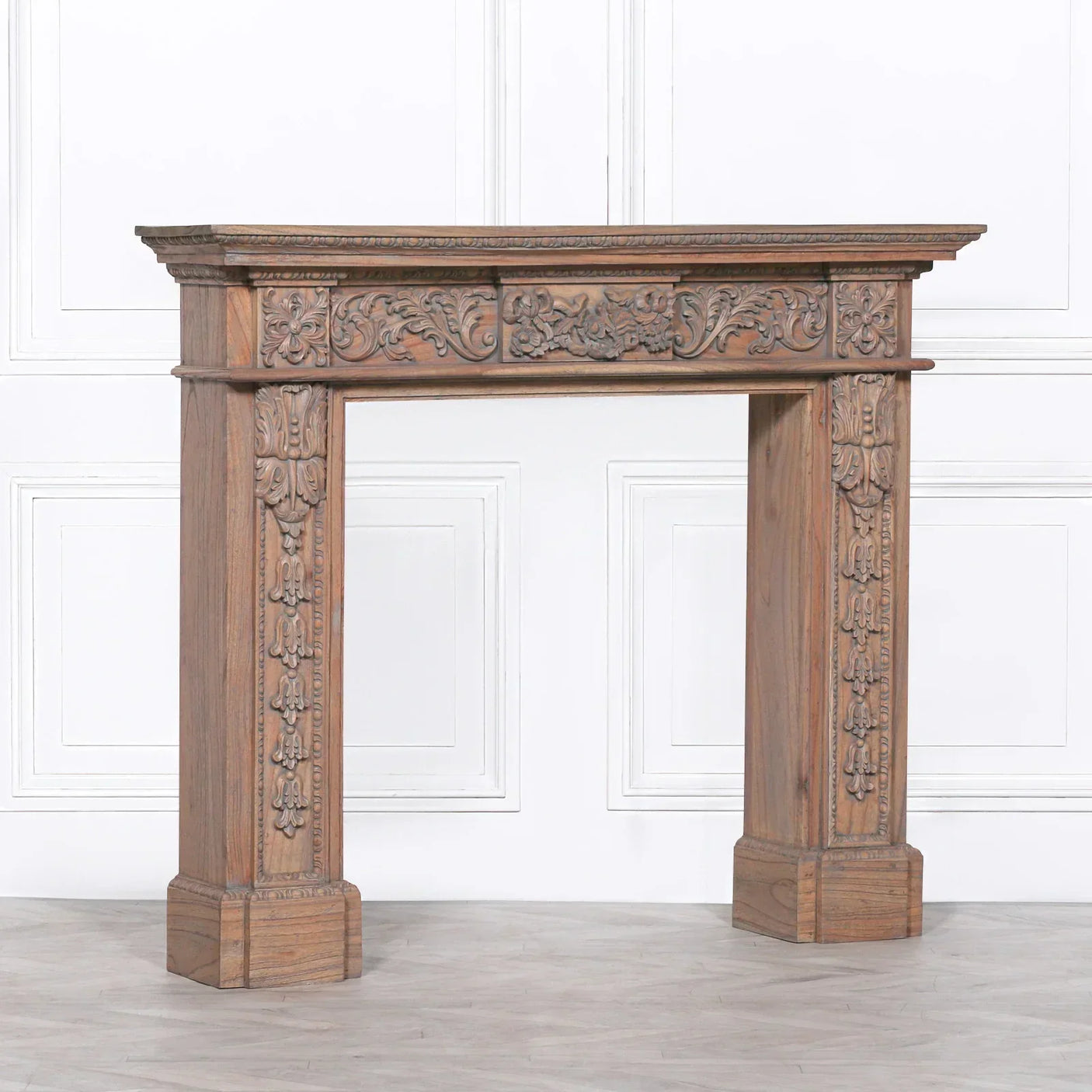 Ornate carved wood fireplace surround with floral detailing and natural finish
