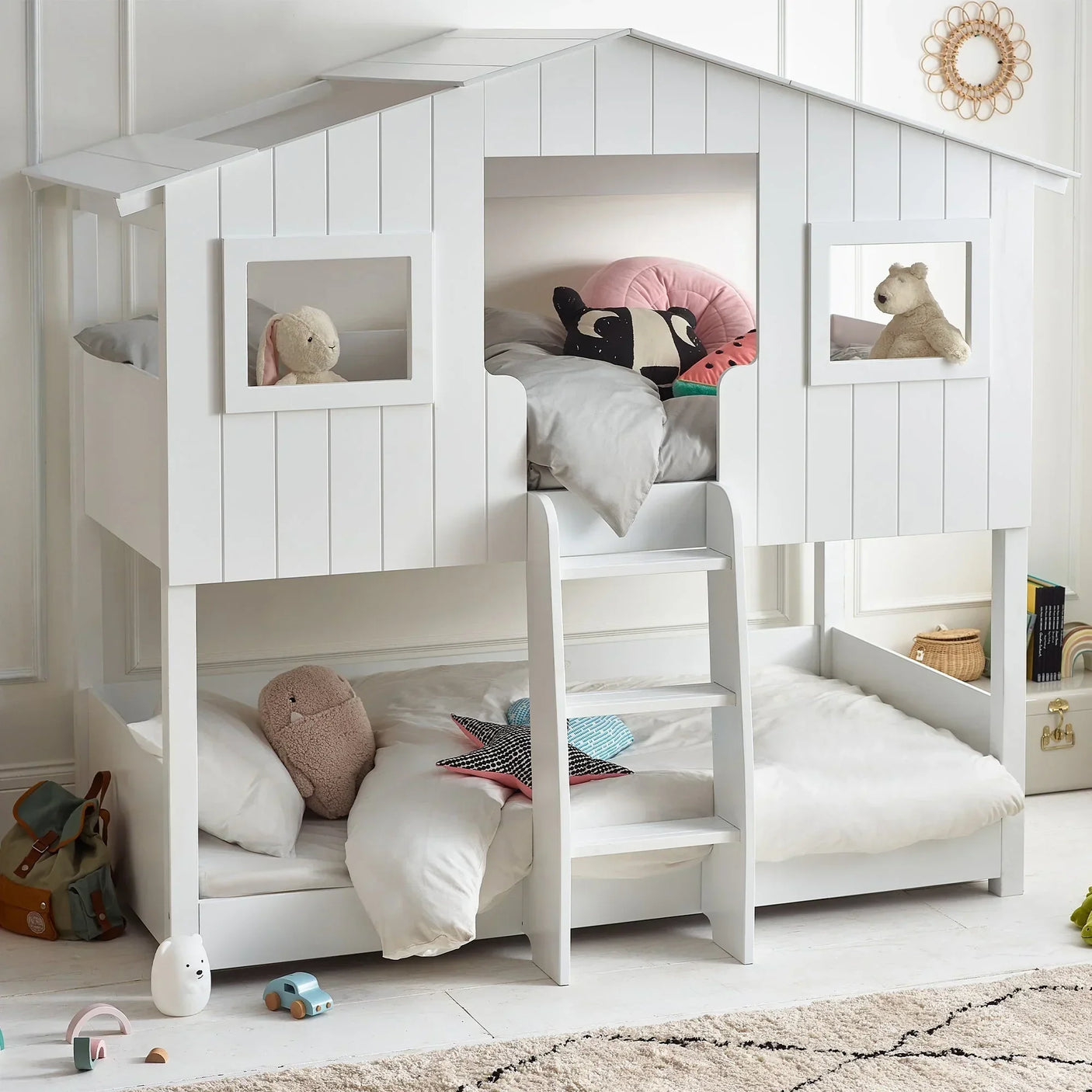 white wooden treehouse bunk bed with ladder and plush toys in kids bedroom setting