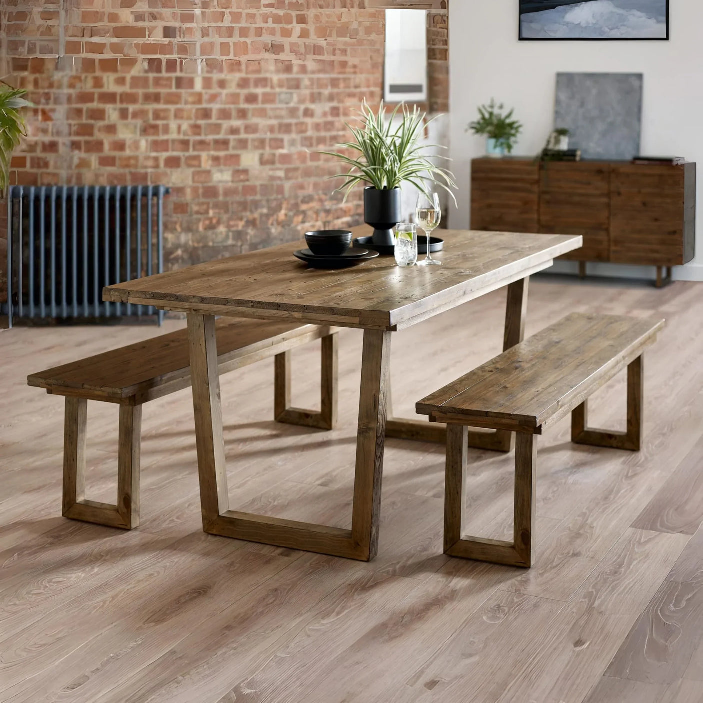 Rustic wooden dining table with matching benches in modern dining room setting