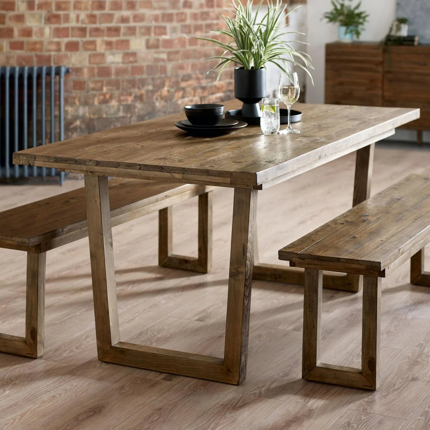Rustic wooden dining table with matching benches in a modern dining room setting