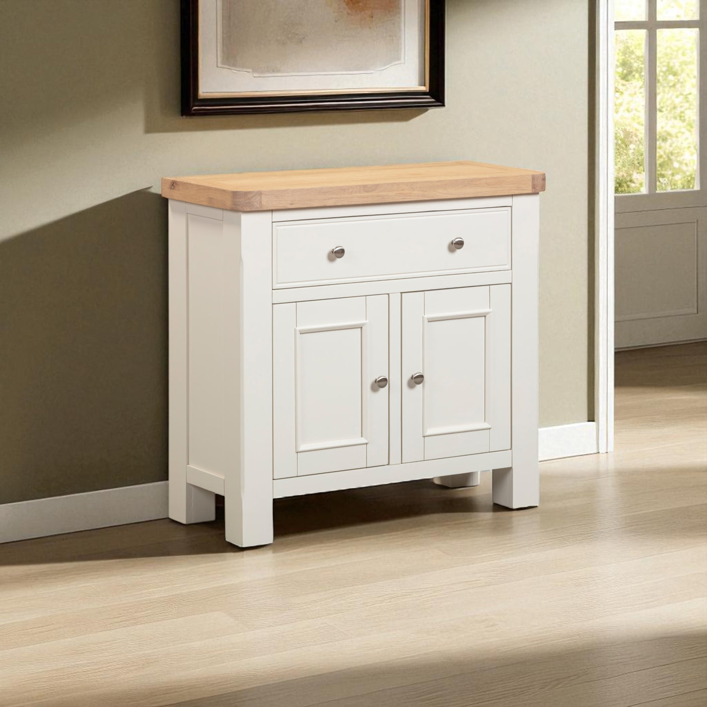 White sideboard with wooden top in a room with a window and framed picture.