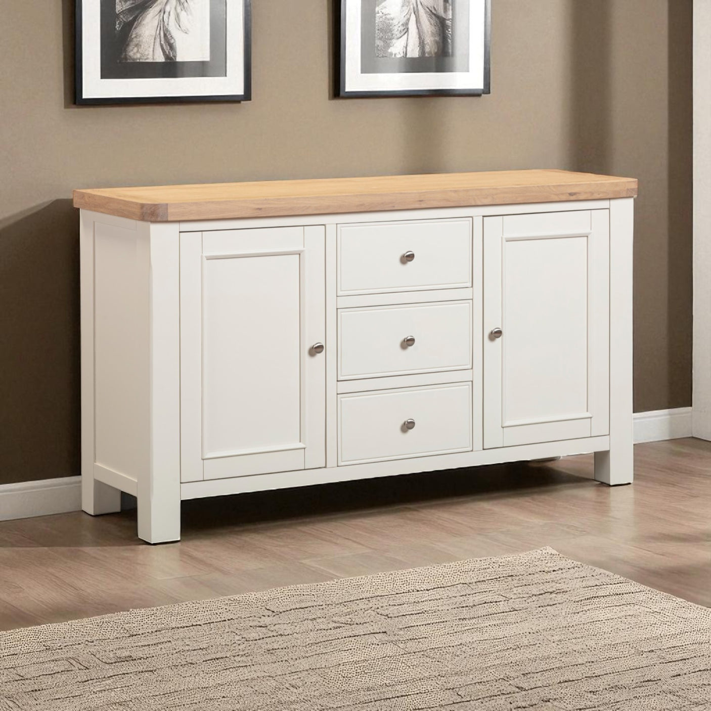 White sideboard with wooden top in a room with framed pictures on the wall.