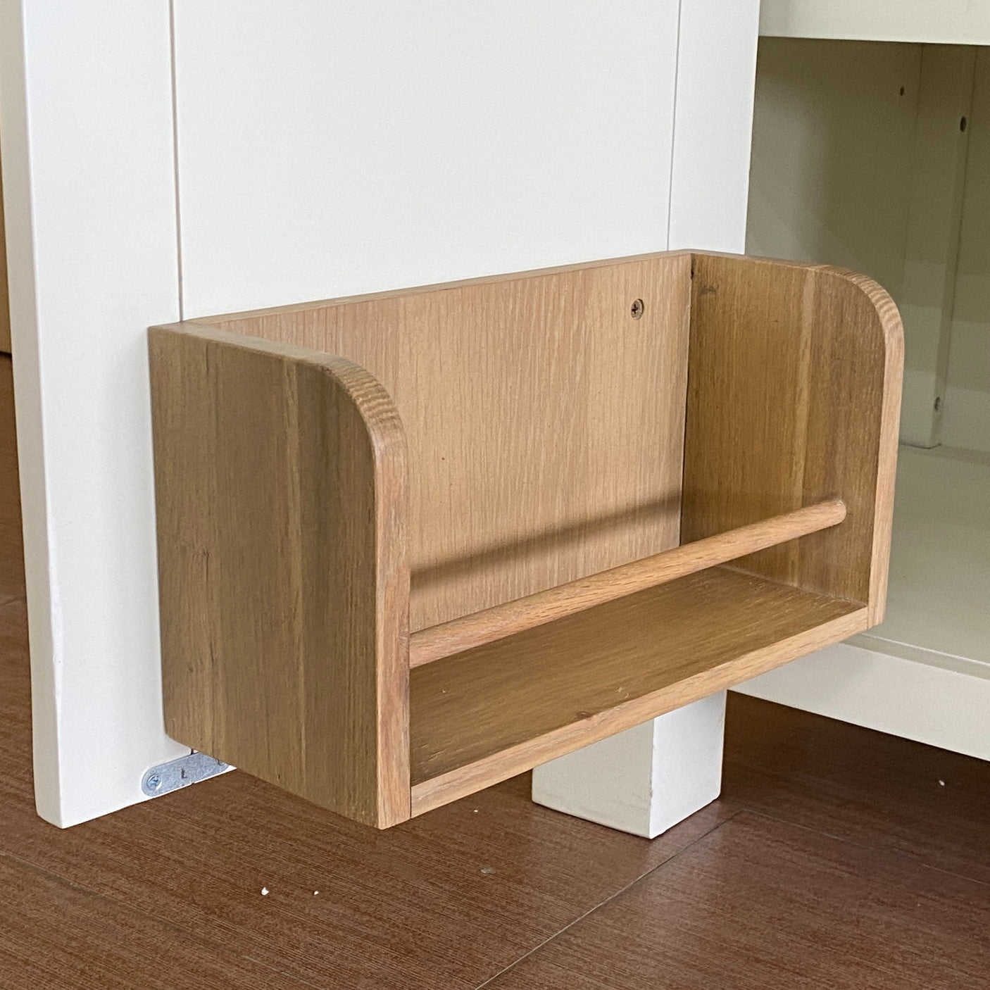 Wooden shelf attached to a white wall