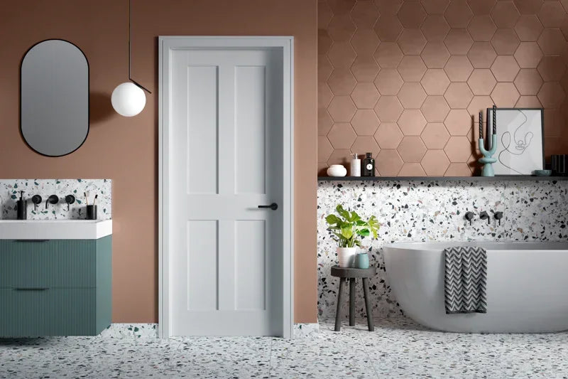 White four panel interior door in modern bathroom with terrazzo tiles and freestanding bath
