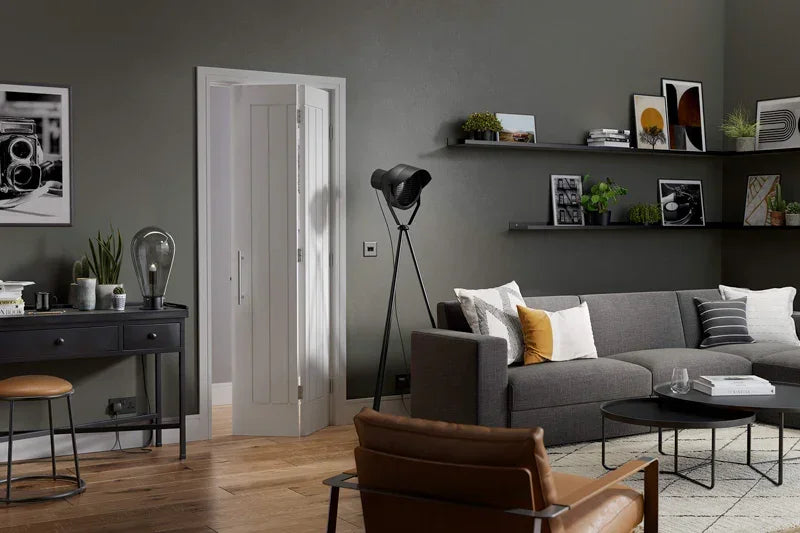 White Mexicano bi-fold door open in modern living room with grey walls and wooden floor