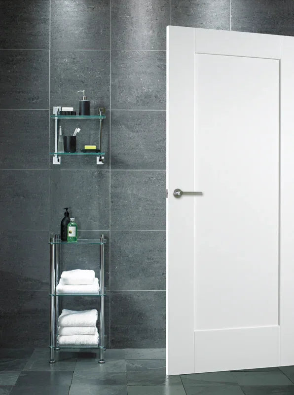 White shaker interior door in modern bathroom with dark tile wall and chrome handle