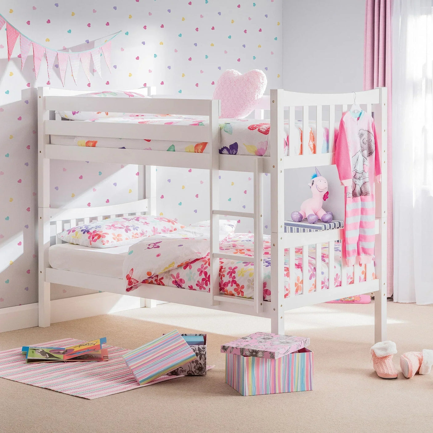 White bunk bed with ladder in kids room, floral bedding and pastel decor accents