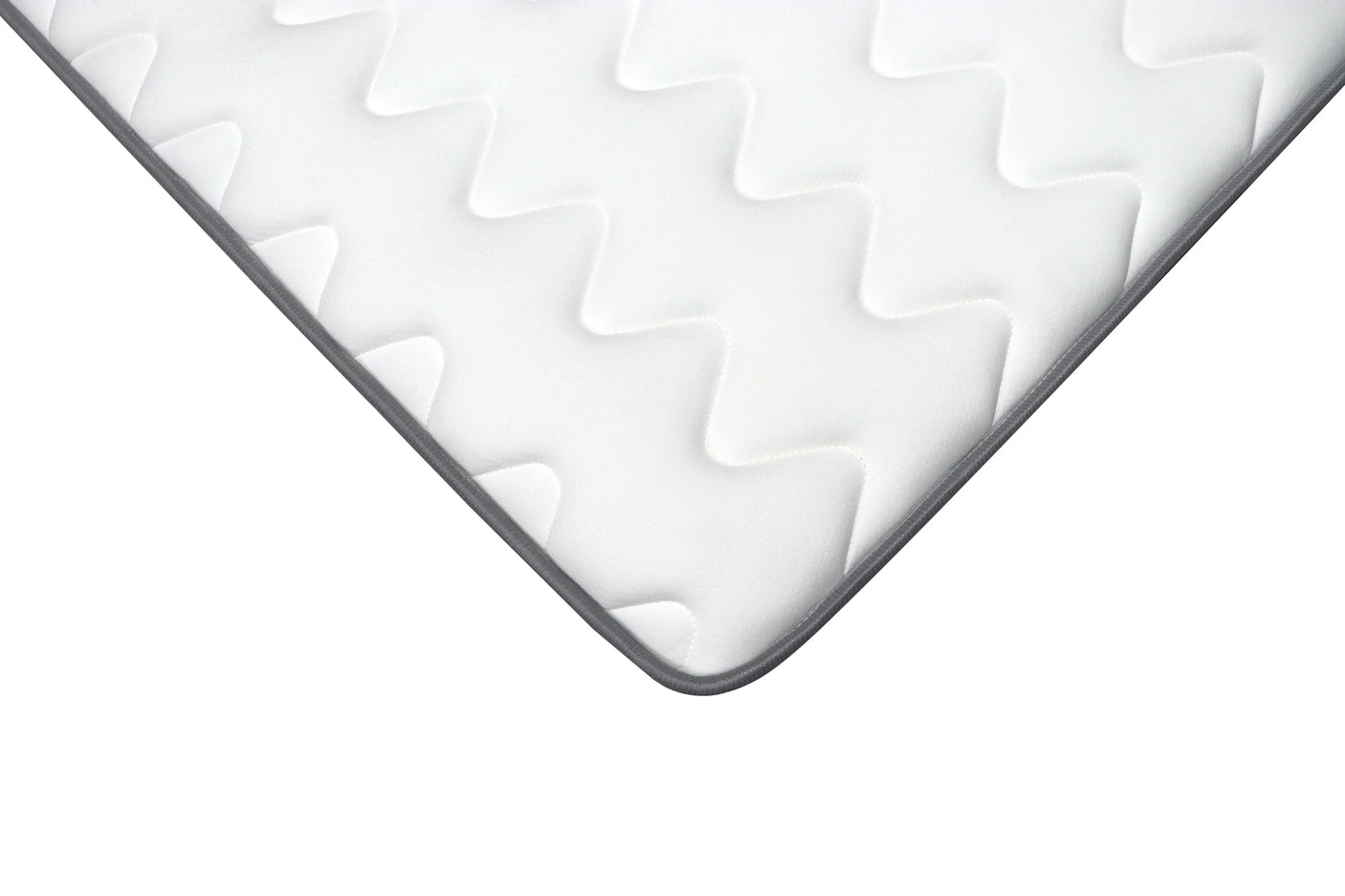 Corner detail of white mattress with quilted zigzag pattern and grey edge trim
