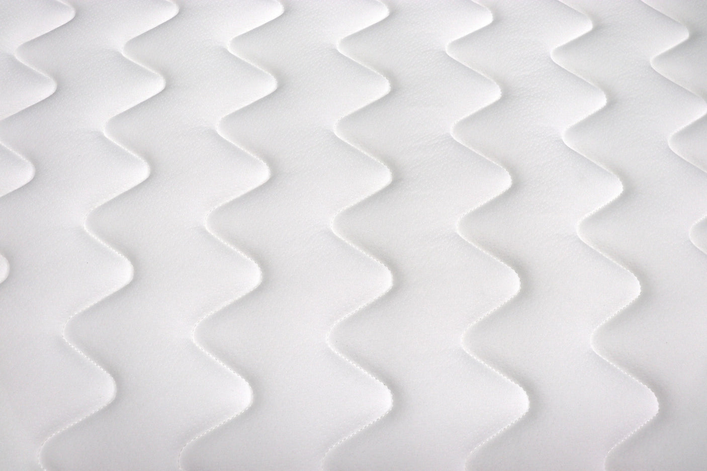 white mattress close-up with zigzag quilted stitching pattern
