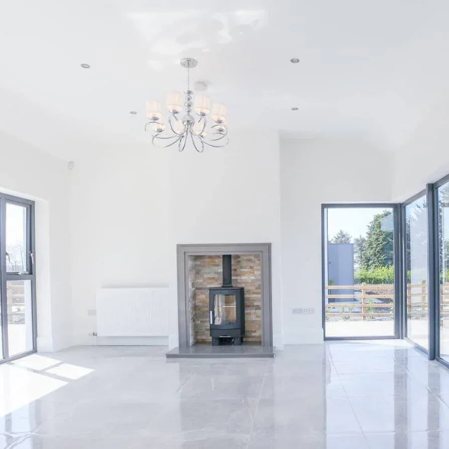 Modern living room with floor tiles, wood burning stove and large sliding glass doors