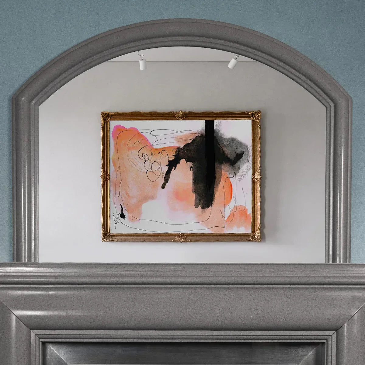 Grey arched overmantle mirror with sculpted frame mounted above a fireplace