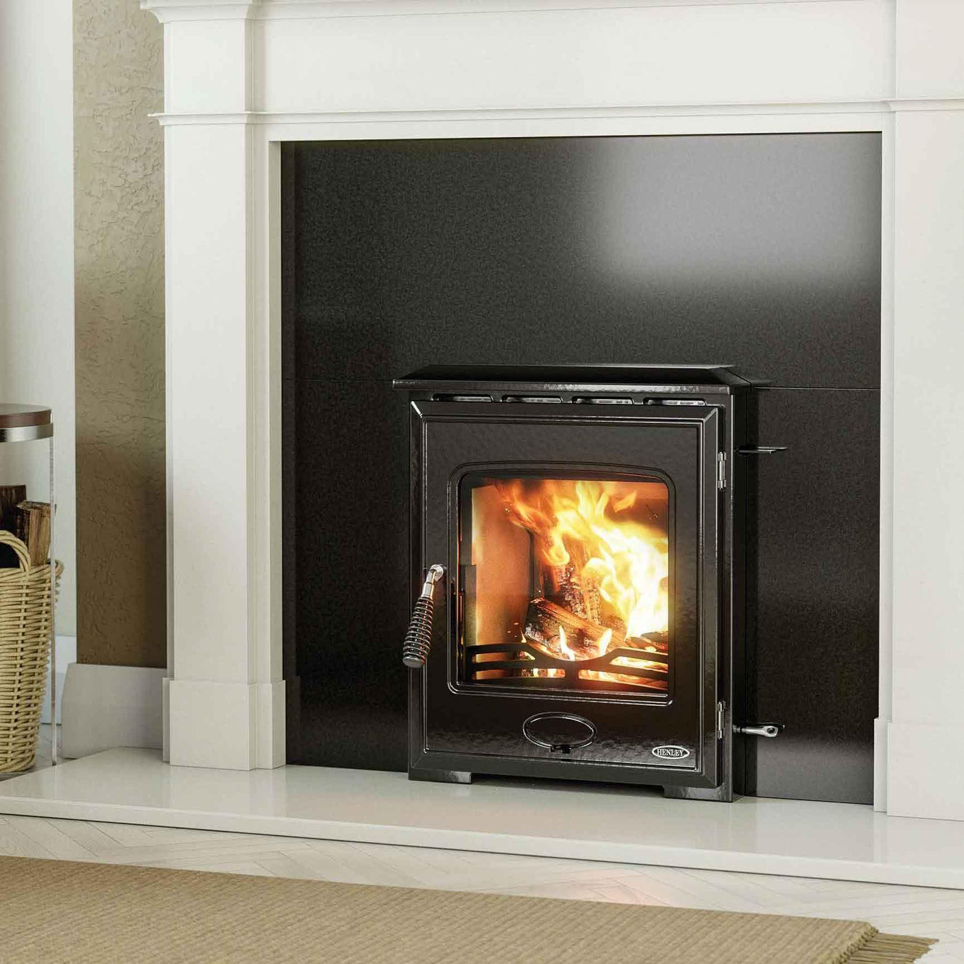 Black wood burning stove with glass door set in modern fireplace surround