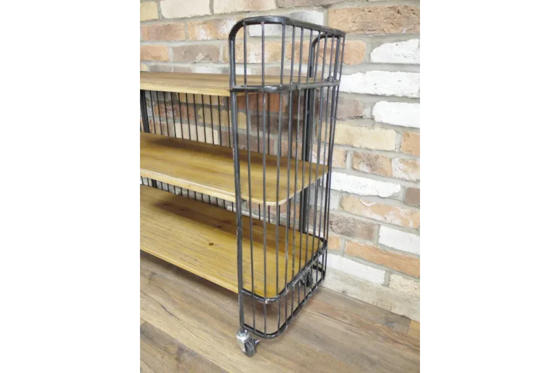 Industrial style shelving unit with metal frame, wooden shelves and wheels on wood floor