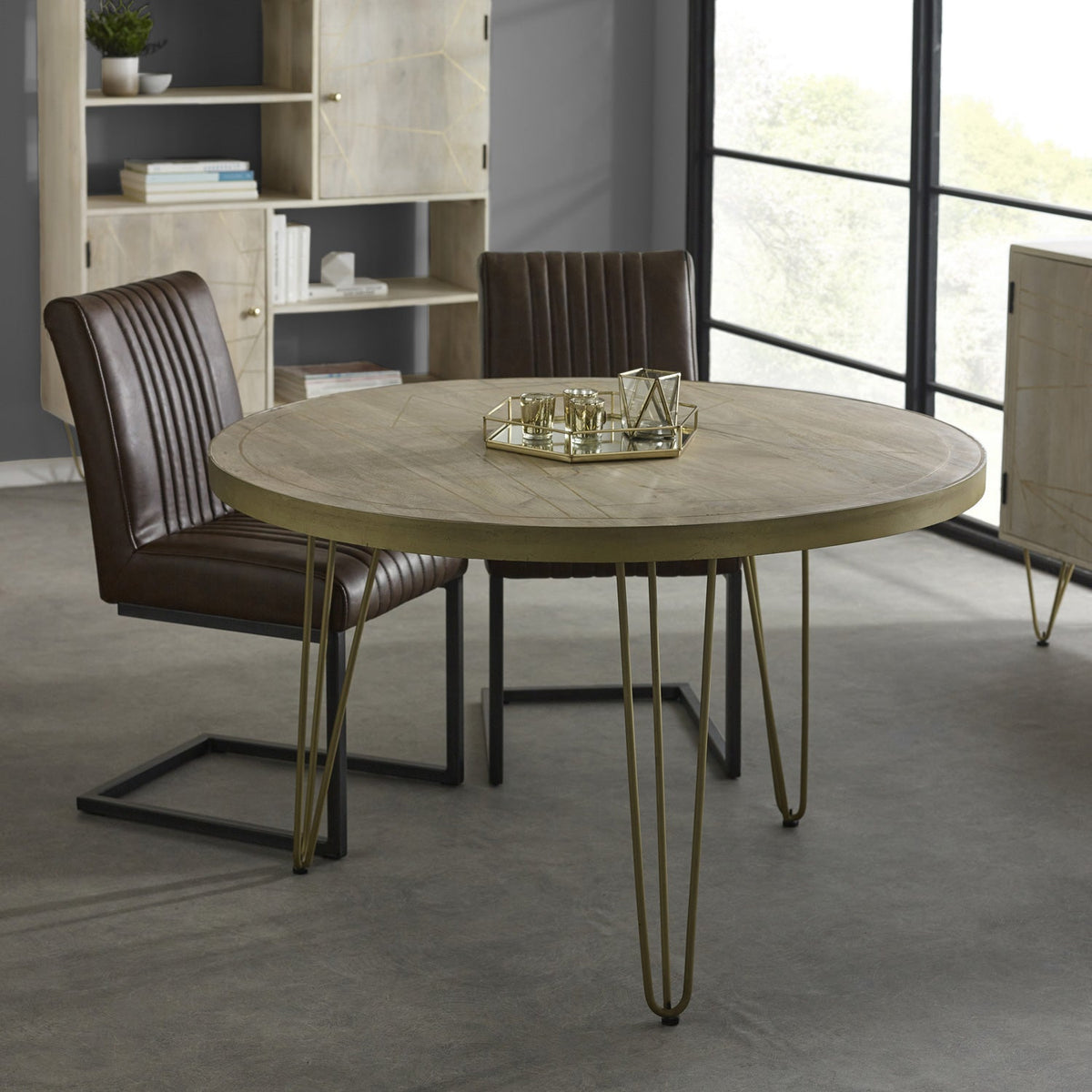 Light gold round dining table with metal inlays and angled legs