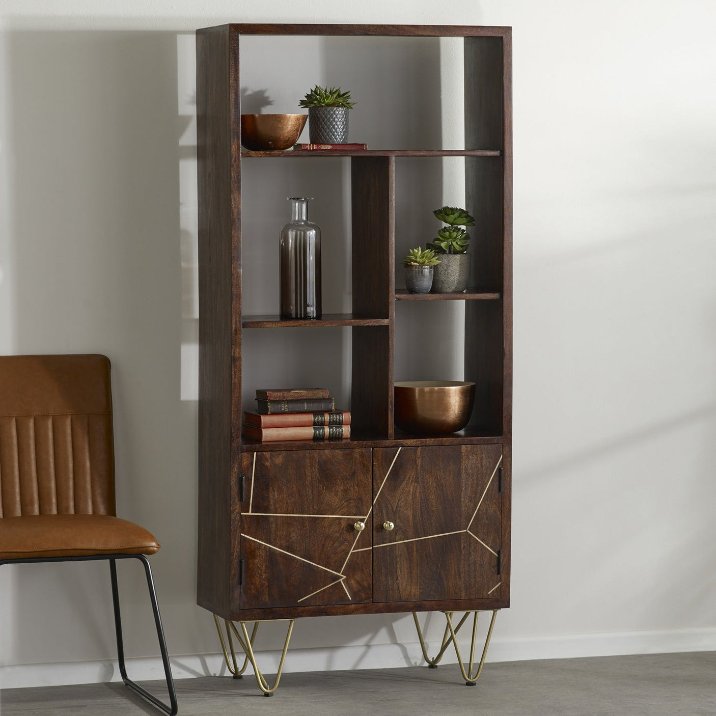 Dark gold large bookcase with metal inlays and angled legs in a contemporary living room