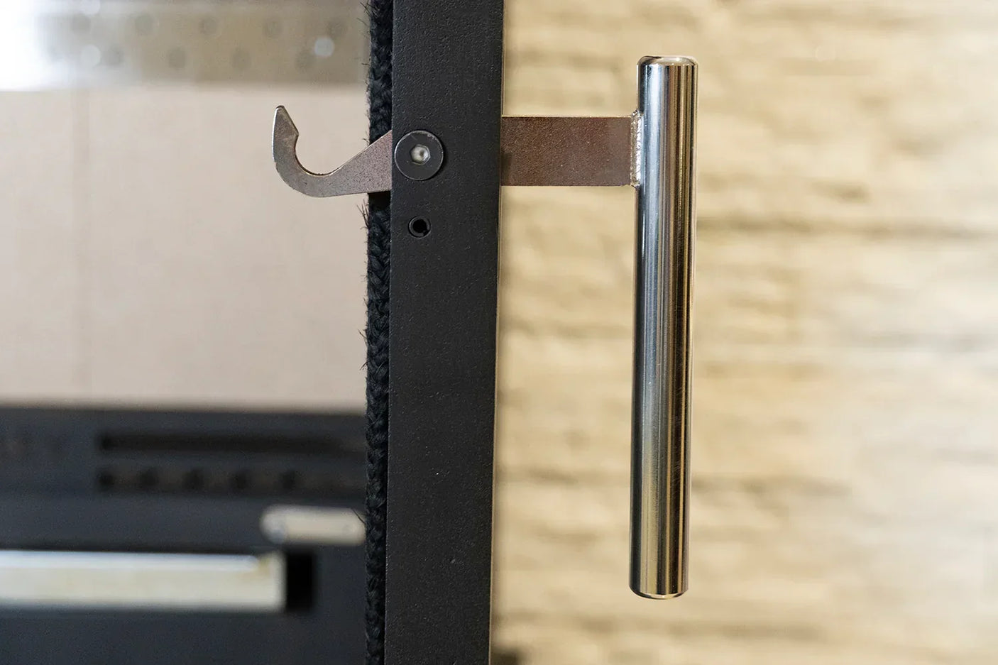 Stainless steel door handle hook with black frame mounted on vertical surface