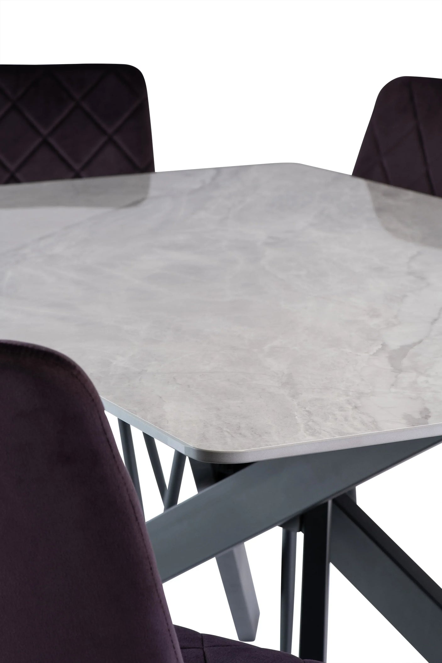 Close up of marble dining table with metal legs and quilted dark upholstered chairs