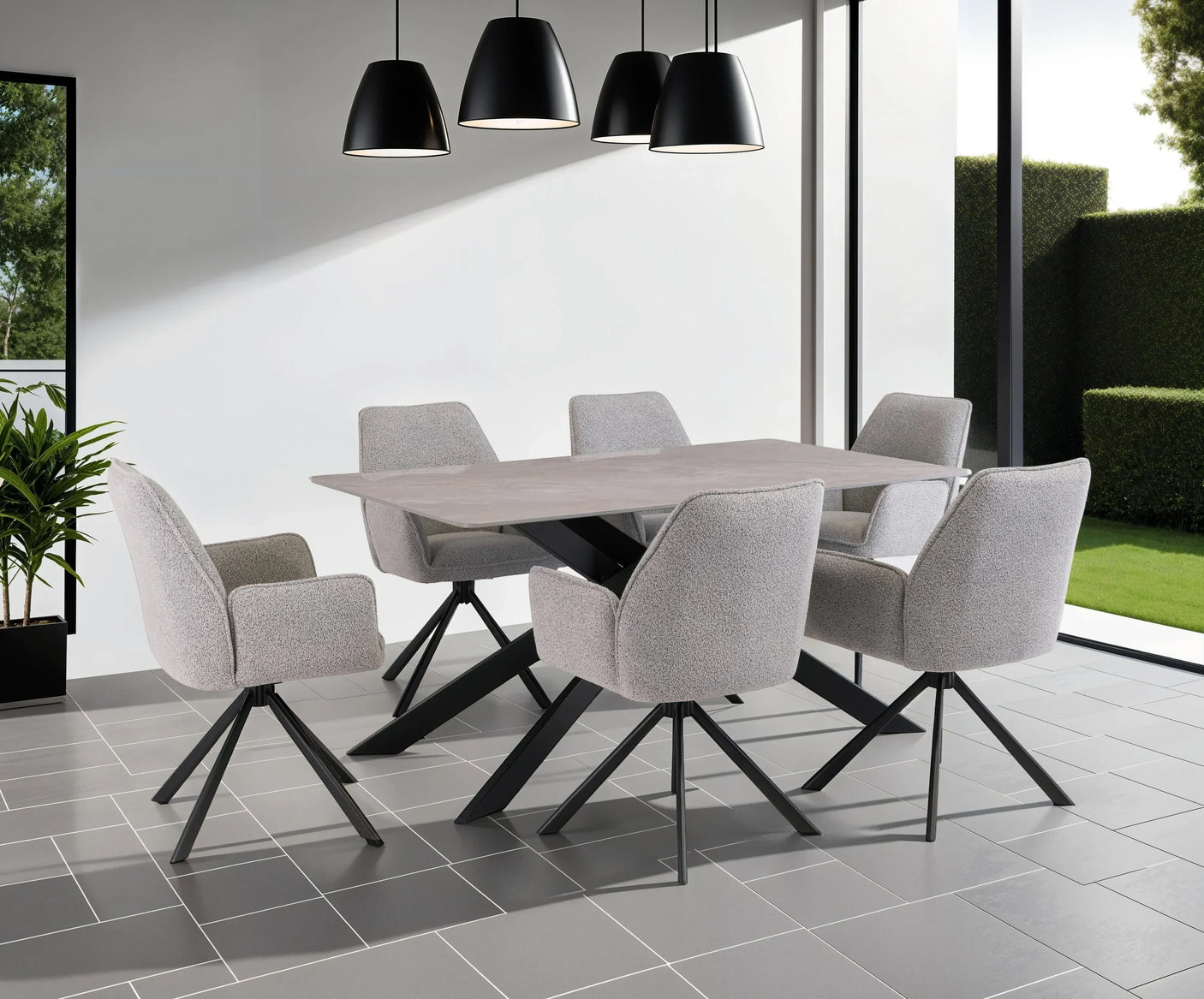 Modern dining table with six grey upholstered chairs in bright room with black pendant lights
