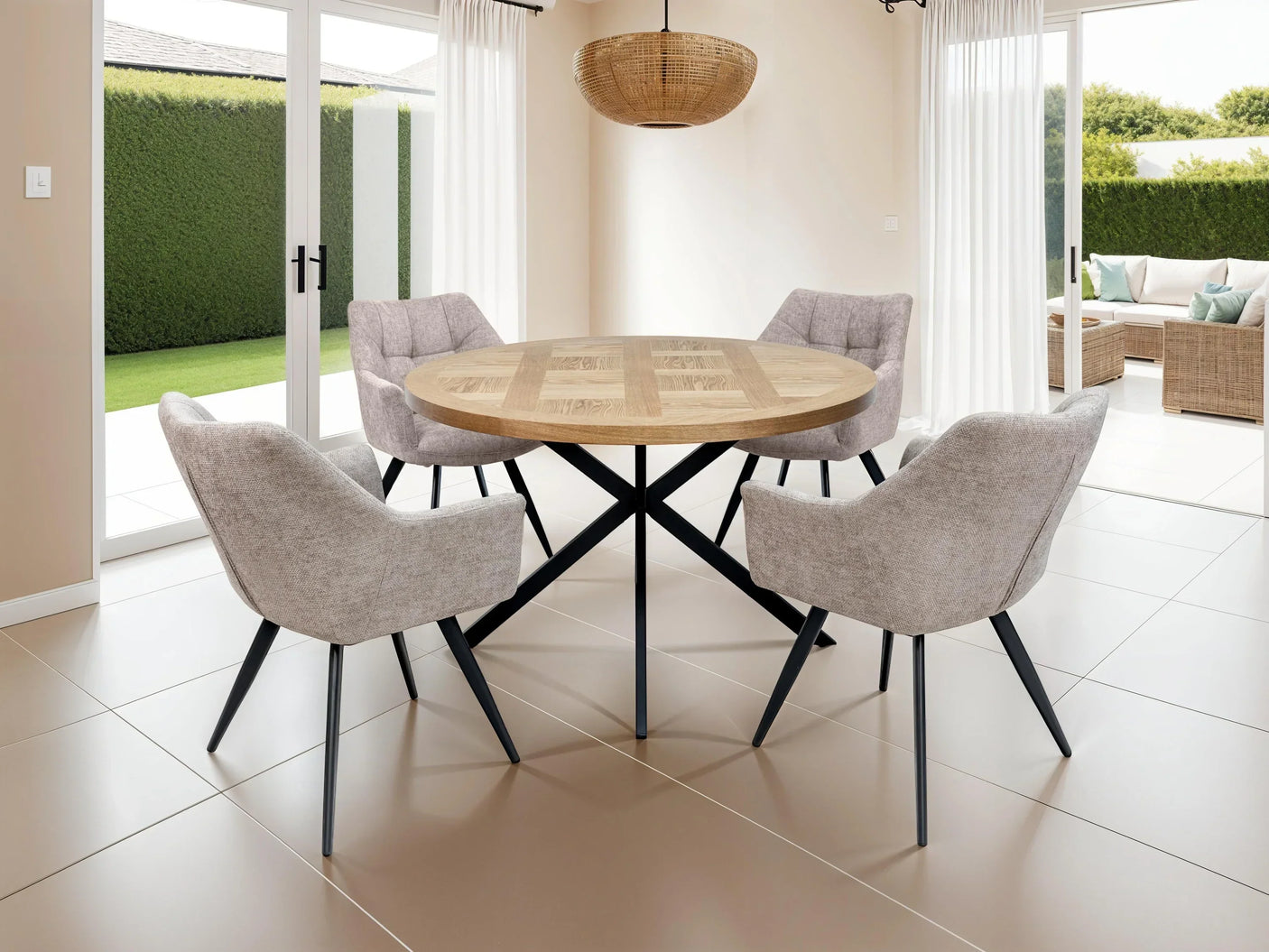 Round wooden dining table with four modern grey fabric chairs in bright dining room