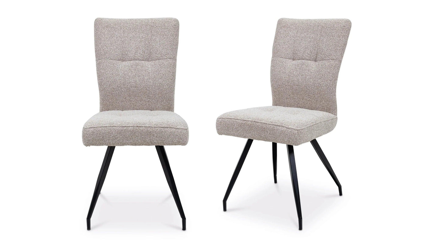 Pair of beige fabric dining chairs with black angled metal legs on white background