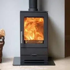 Black wood burning stove with glass door and visible flames, set on a black hearth