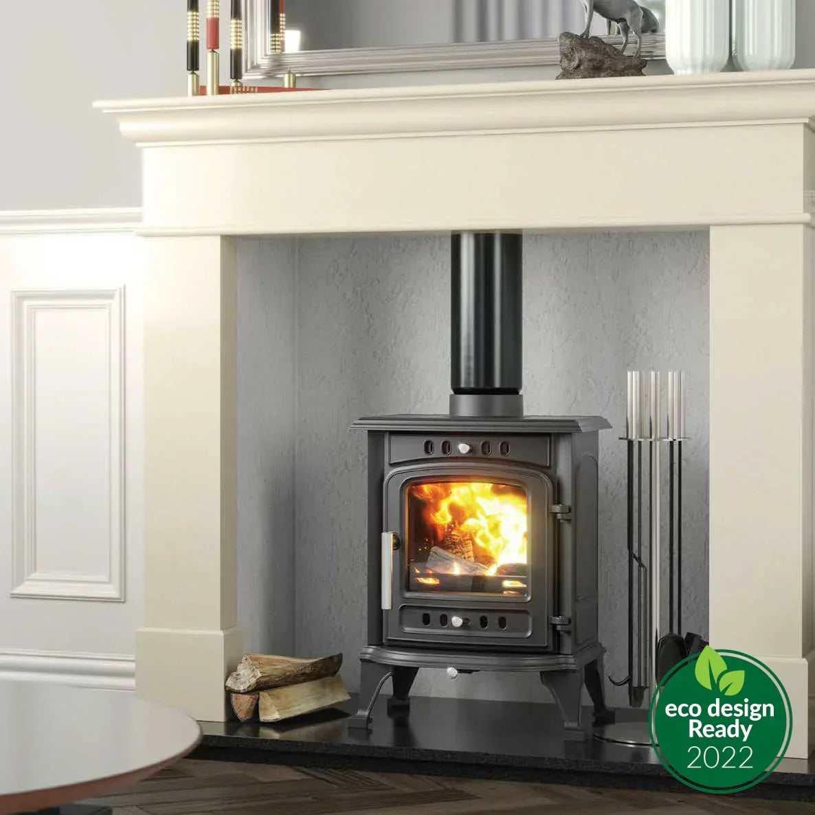 Black wood burning stove with glass door and flames, set in a white fireplace surround