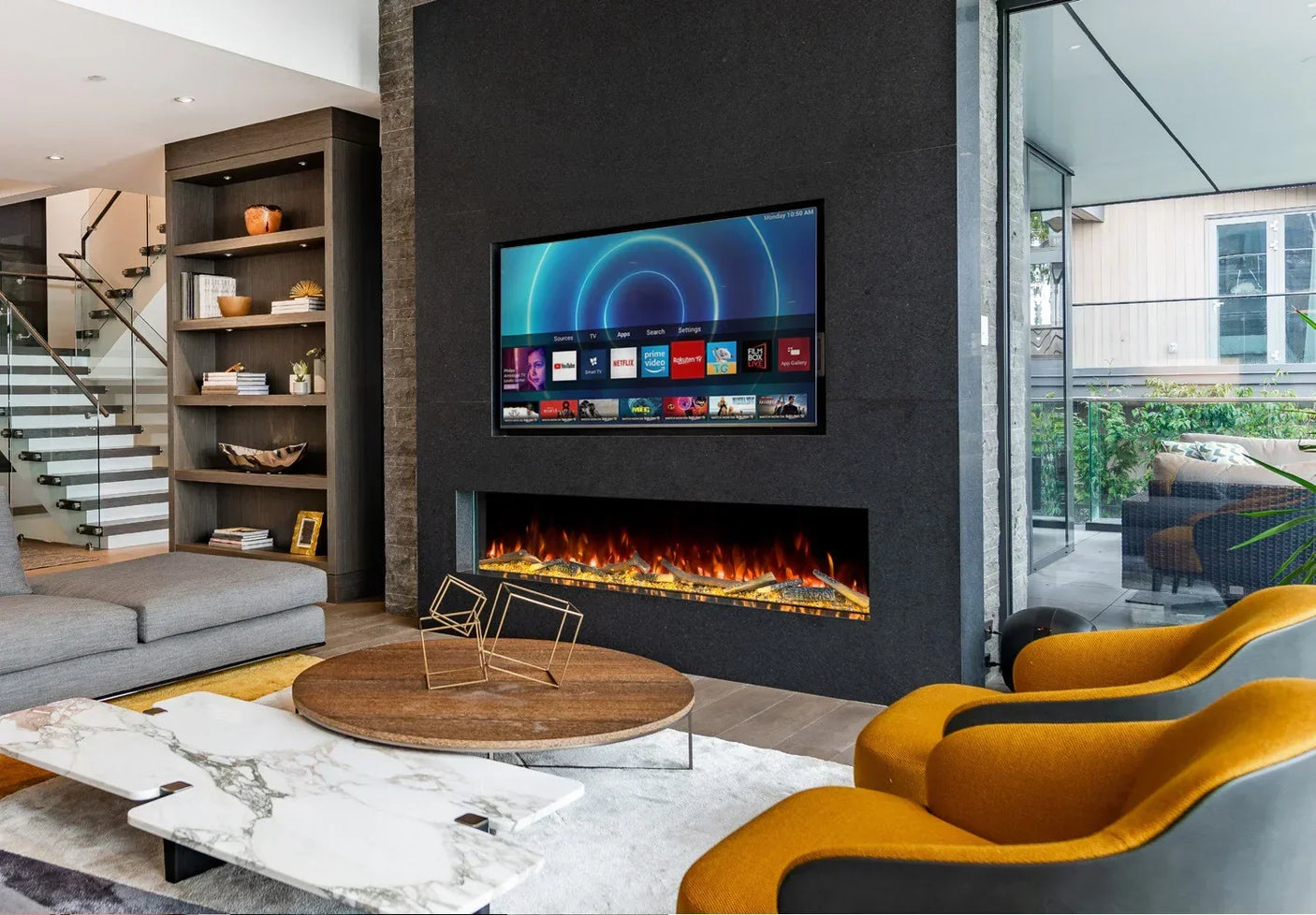 Modern electric fireplace in living room with black surround, wall-mounted TV, yellow chairs