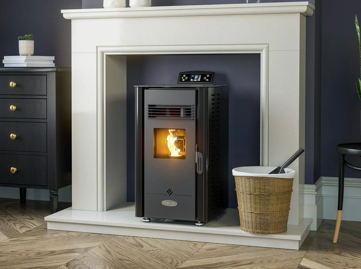 Black freestanding pellet stove with digital display set in cream fireplace, burning flame visible