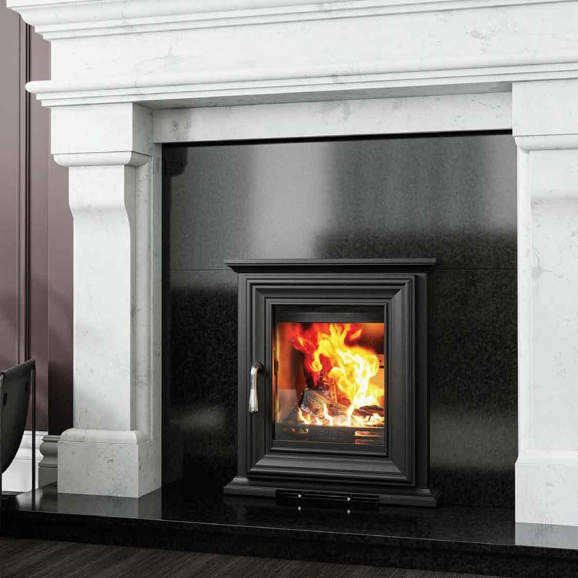 Black wood burning stove with glass door set in marble fireplace surround