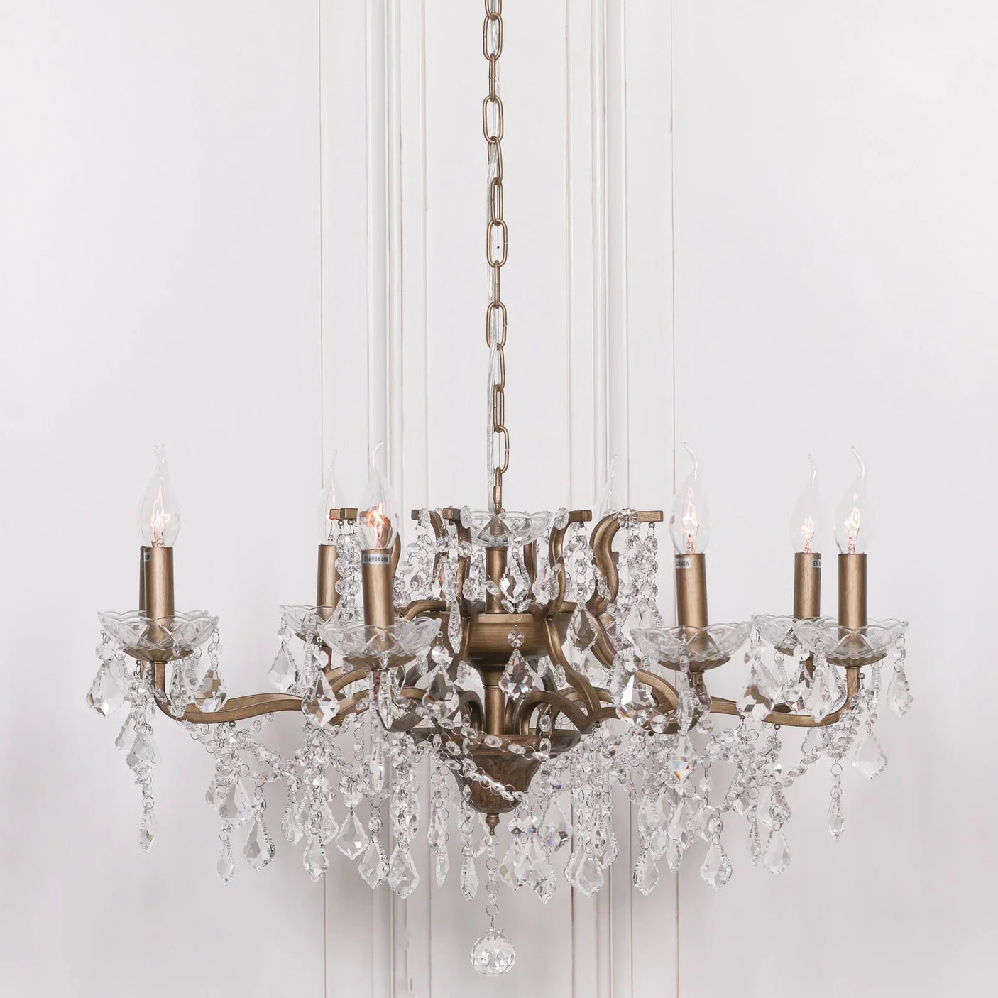 Antique brass and crystal chandelier with candle bulbs and hanging glass droplets