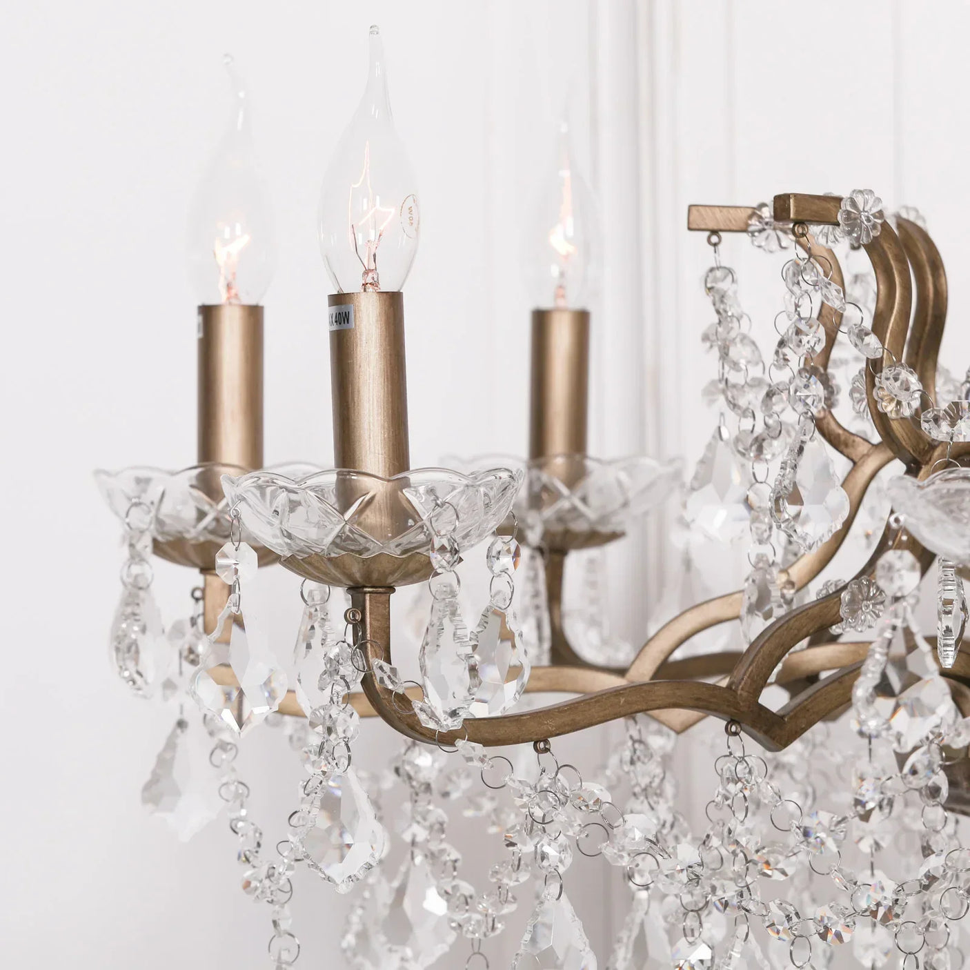 Crystal chandelier detail with gold arms and hanging glass pendants