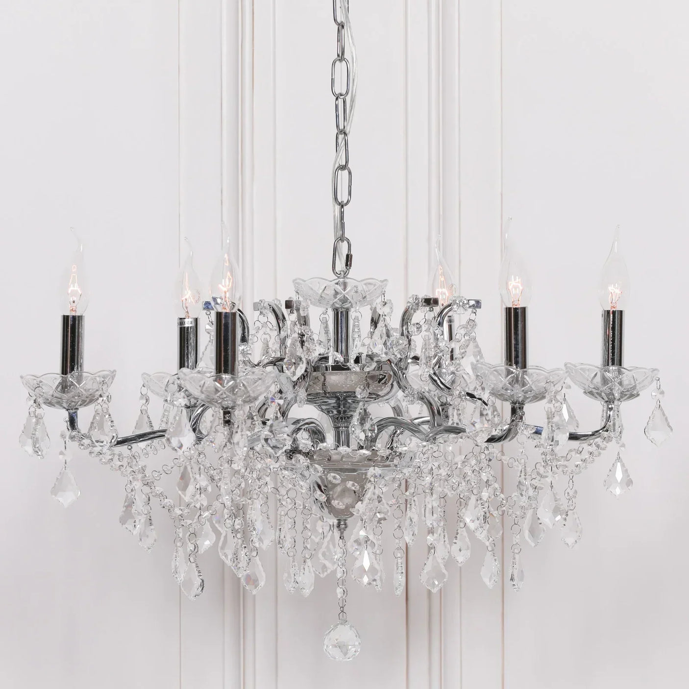 Chrome and crystal chandelier with candle-style LED bulbs and hanging glass drops