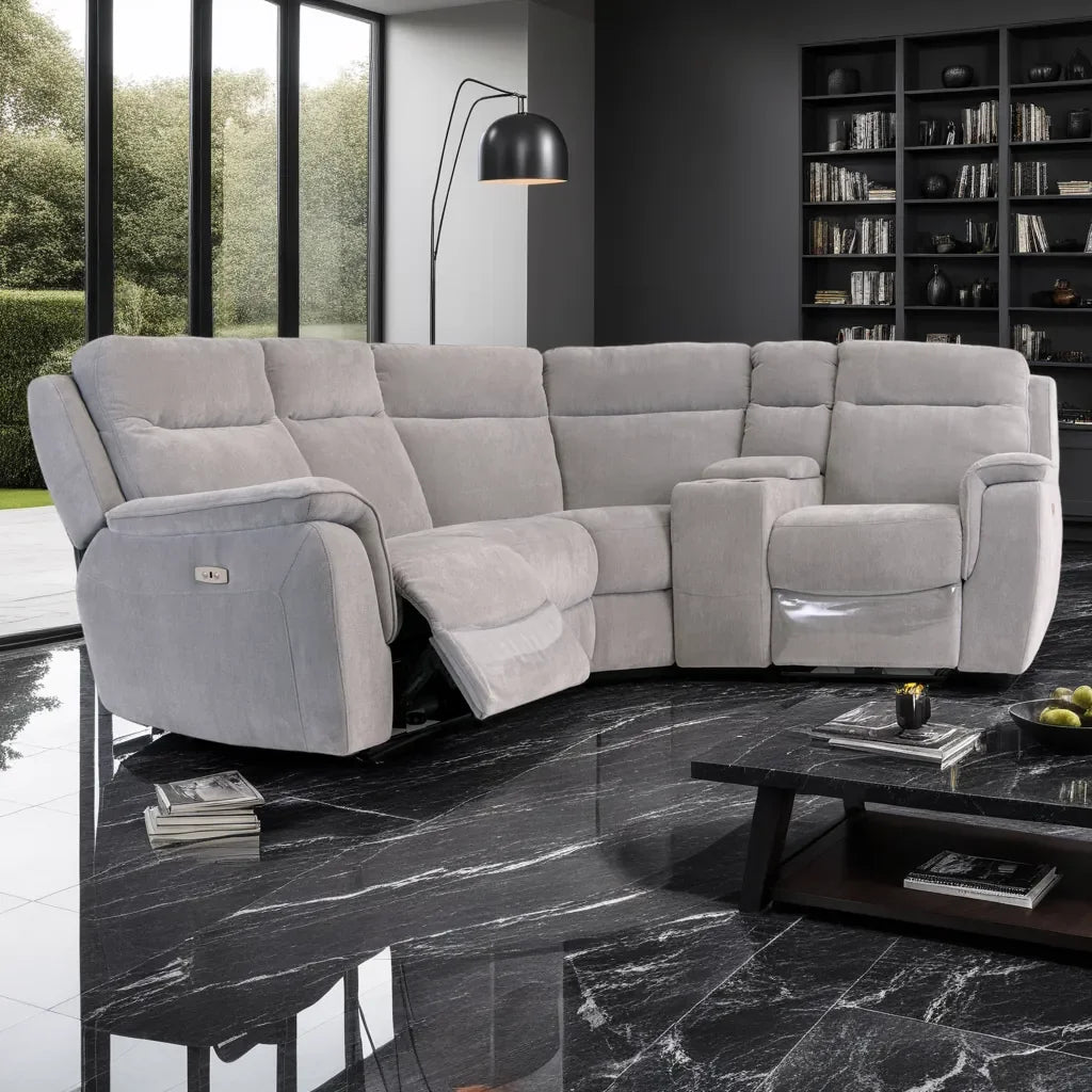 Gray sectional sofa in a modern living room with marble floor and bookshelf.