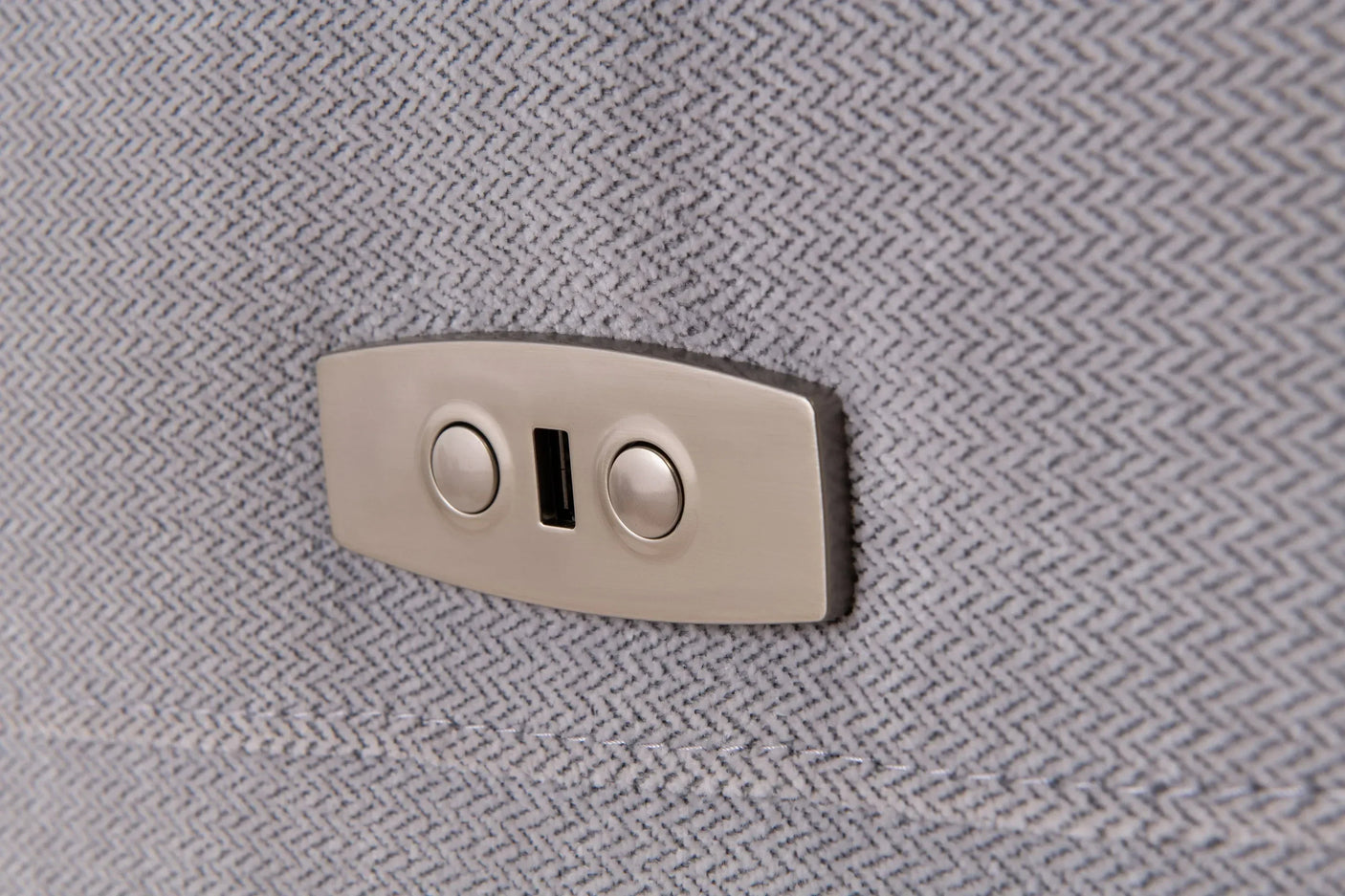 Close-up of silver grey fabric sofa with integrated USB port and chrome buttons