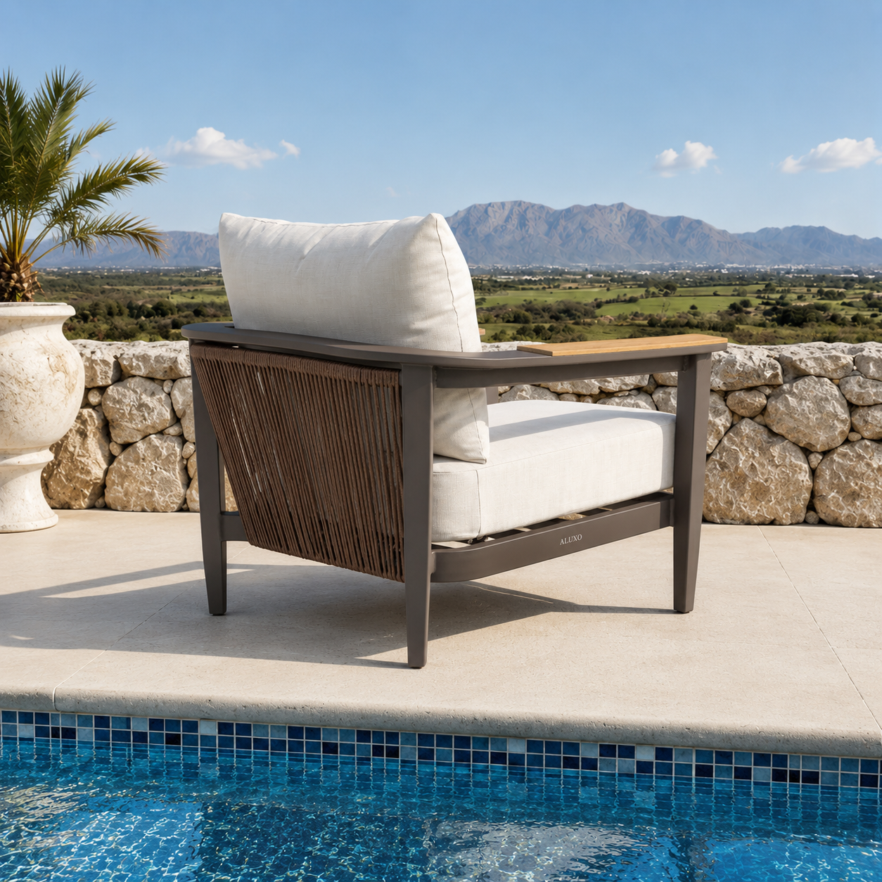 Cream fabric cushions on dark brown metal chair frame with woven rope sides near pool