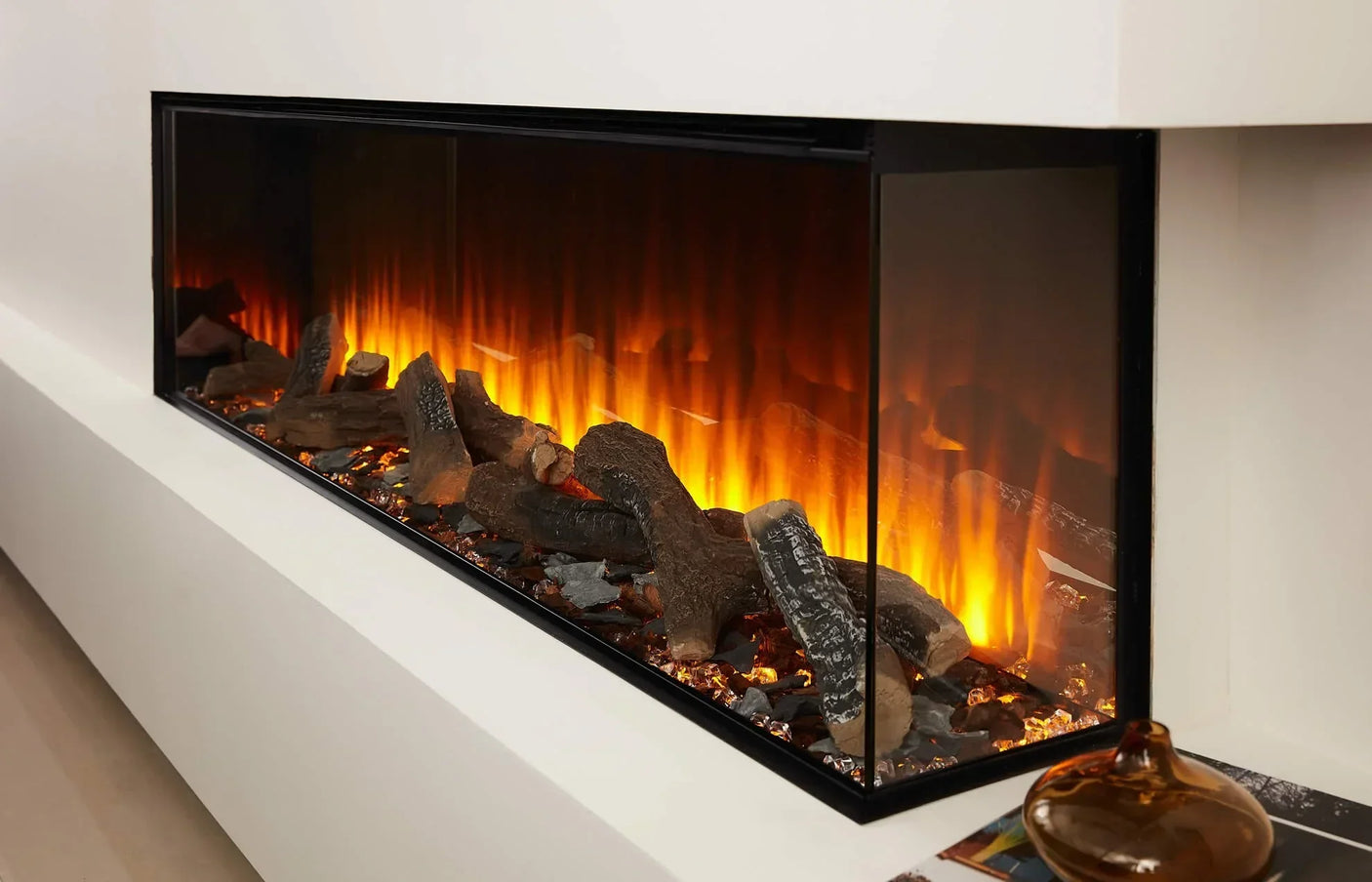 Modern electric fireplace with realistic log set and glowing flame effect in white surround