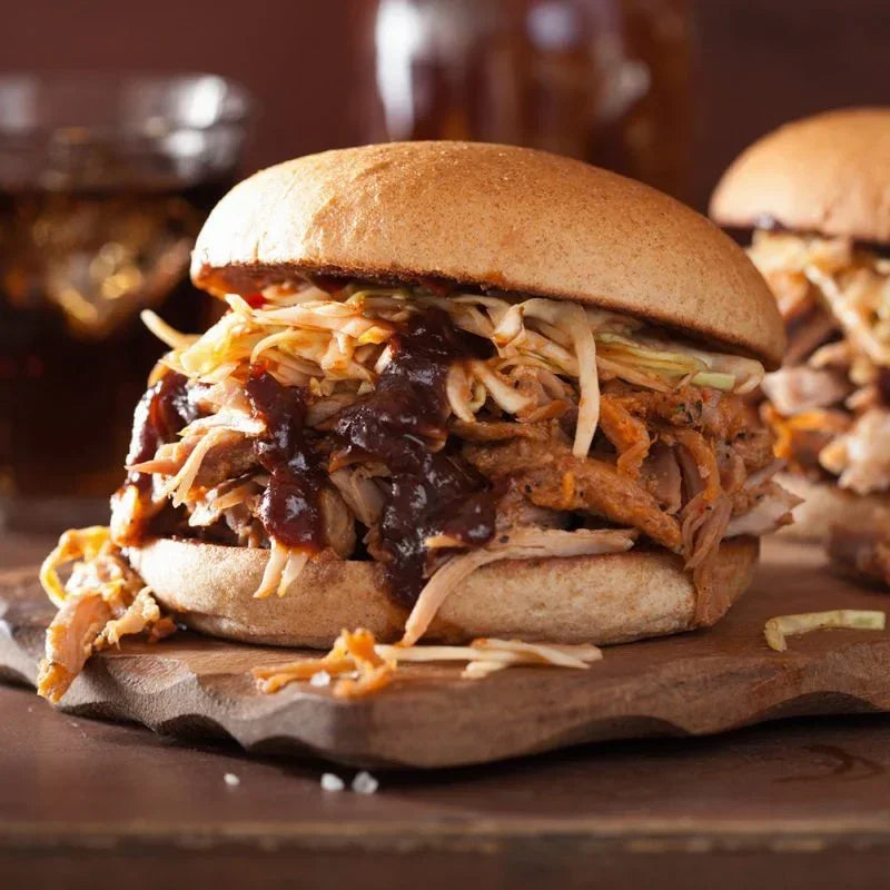 Pulled pork burger with barbecue sauce and slaw served on a wooden board