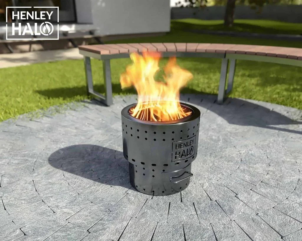 Henley Halo fire pit burning on stone patio with curved bench in garden setting