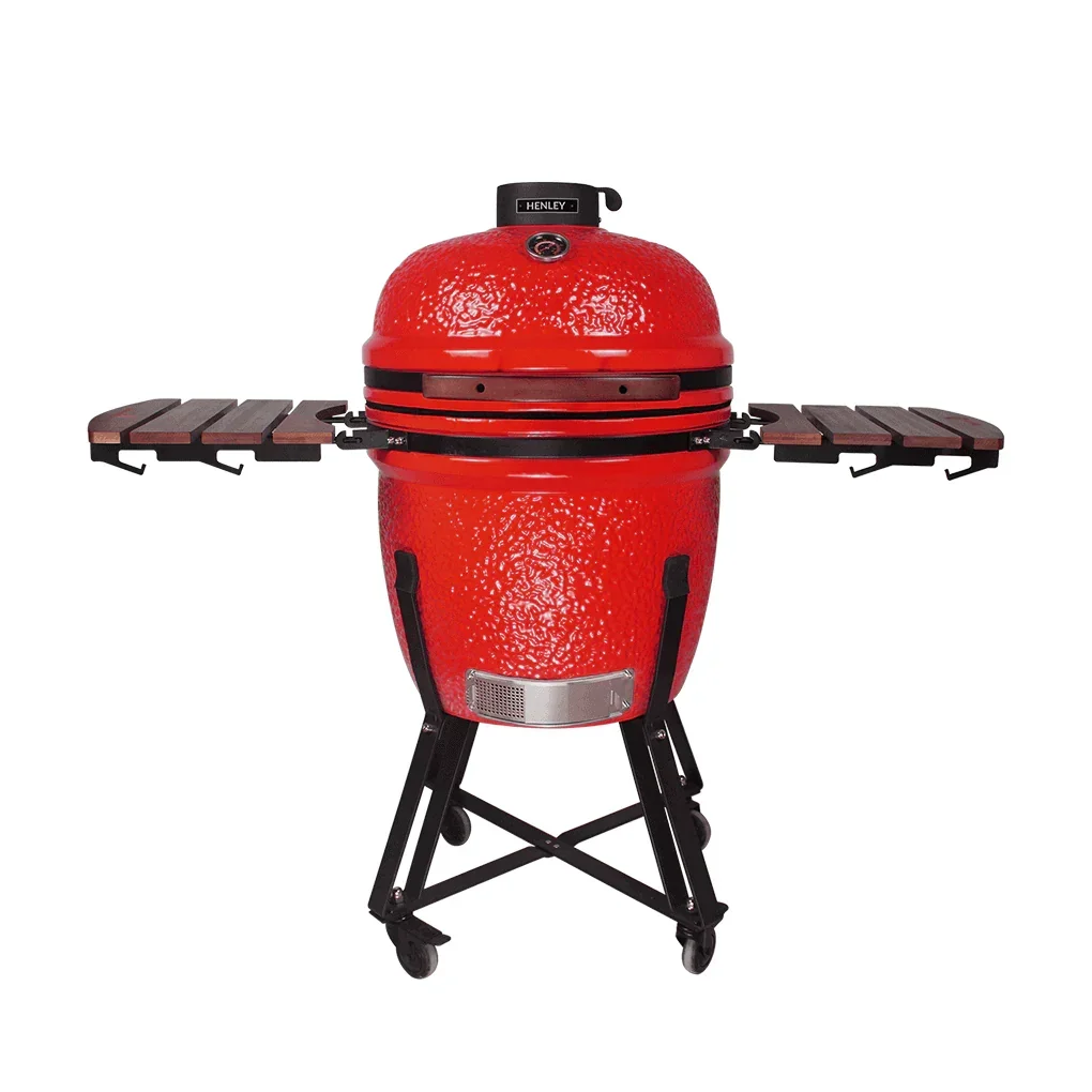 Red ceramic charcoal barbecue grill with wooden side shelves and wheeled metal stand