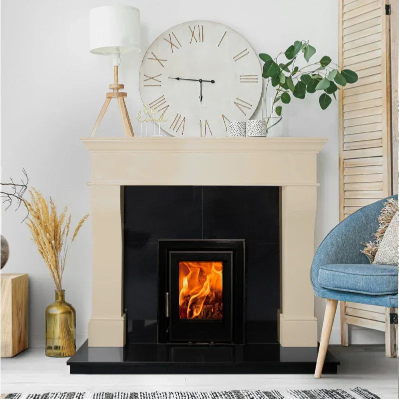 Cream fireplace suite with black stove, decorative clock, and blue accent chair in living room