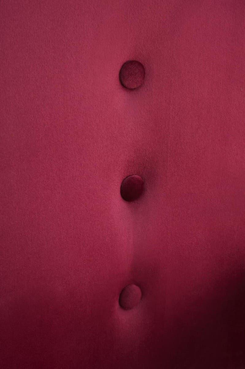 Wine velvet chair close-up showing button detailing on upholstery