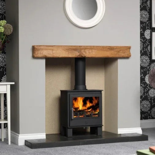 Black wood burning stove with visible flames set in modern living room fireplace