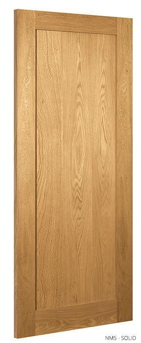 Solid oak internal door with natural wood grain, panelled design, shown upright