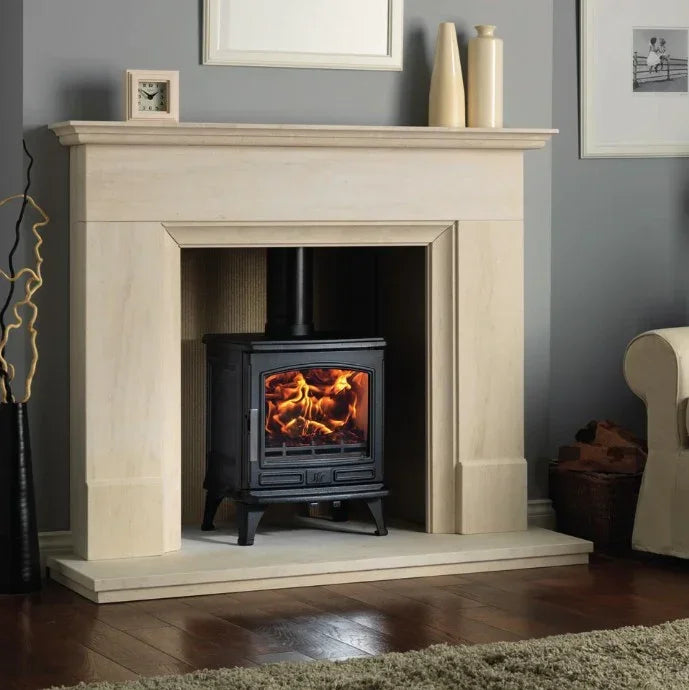Modern oak fireplace with black wood burning stove and burning fire in living room setting