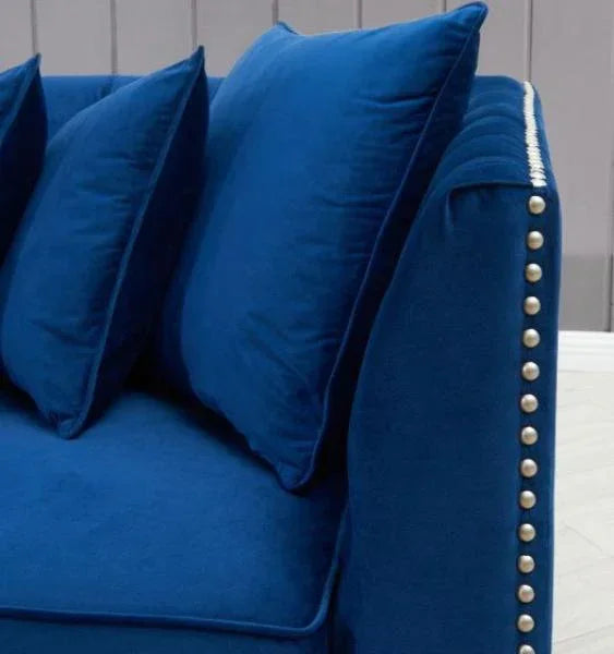 Blue velvet sofa with studded armrest and matching scatter cushions
